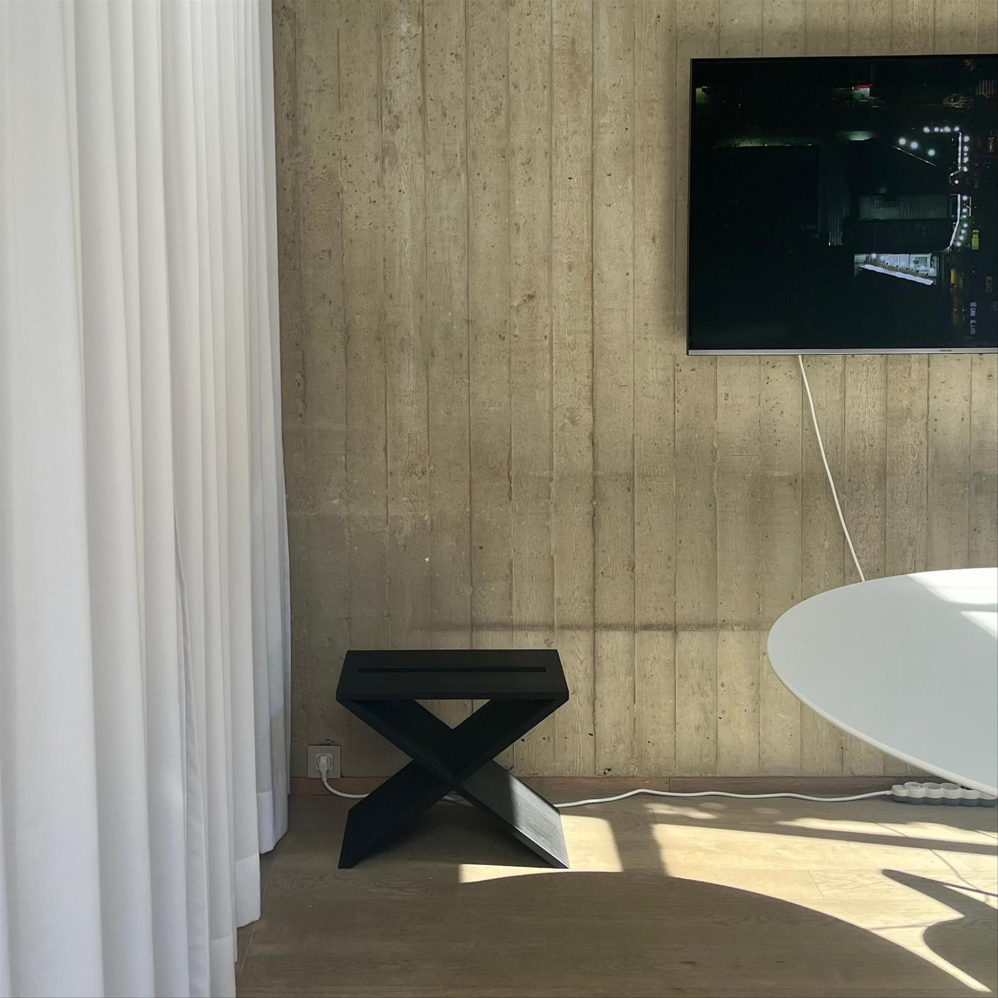 2 chairs, one steel and one wood, on a concrete floor